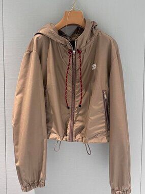 This MIUMIU trench coat paired with a long skirt features excellent tailoring